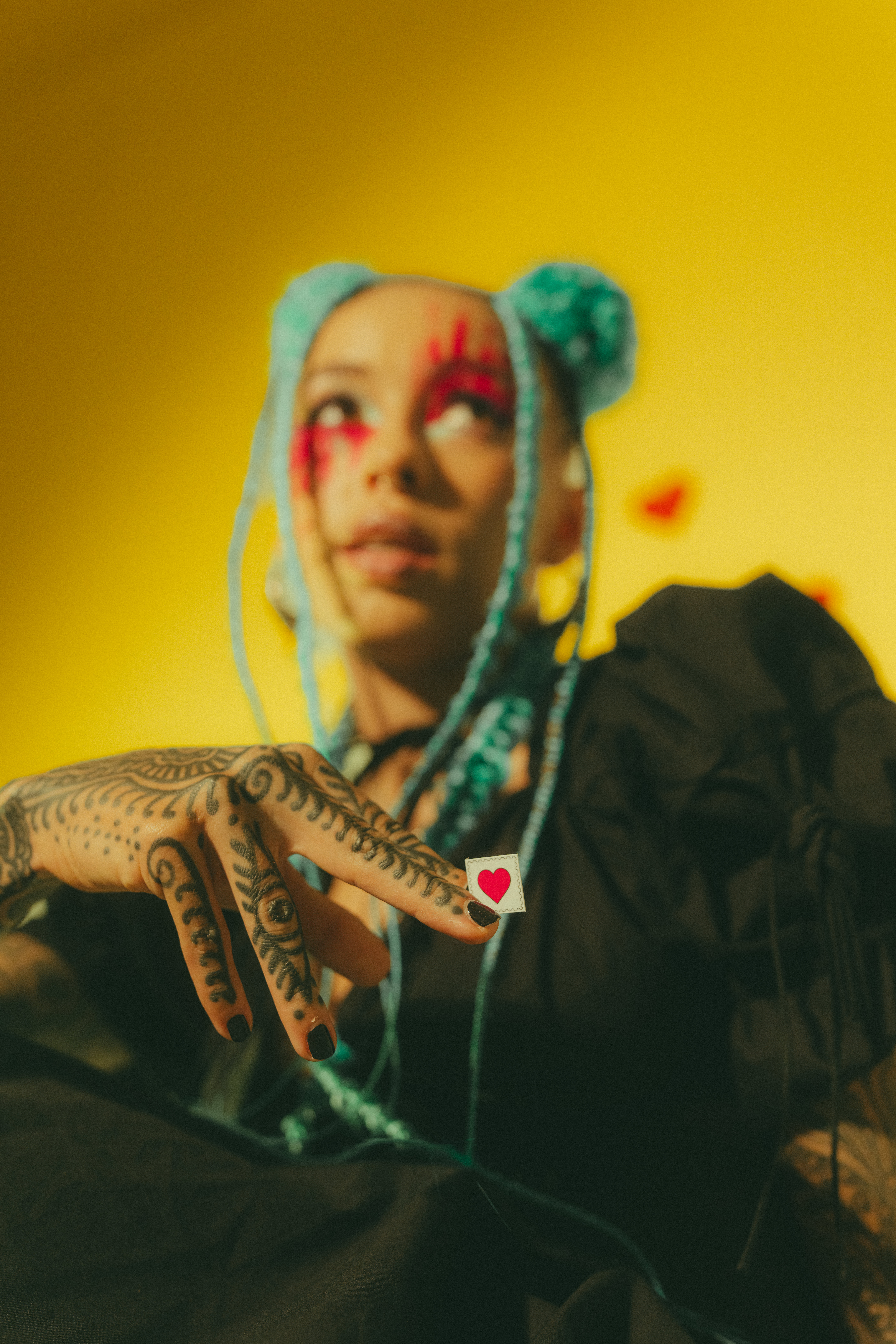 Portrait with blue braids and painted face, hand outstretched — from the performance and modeling work